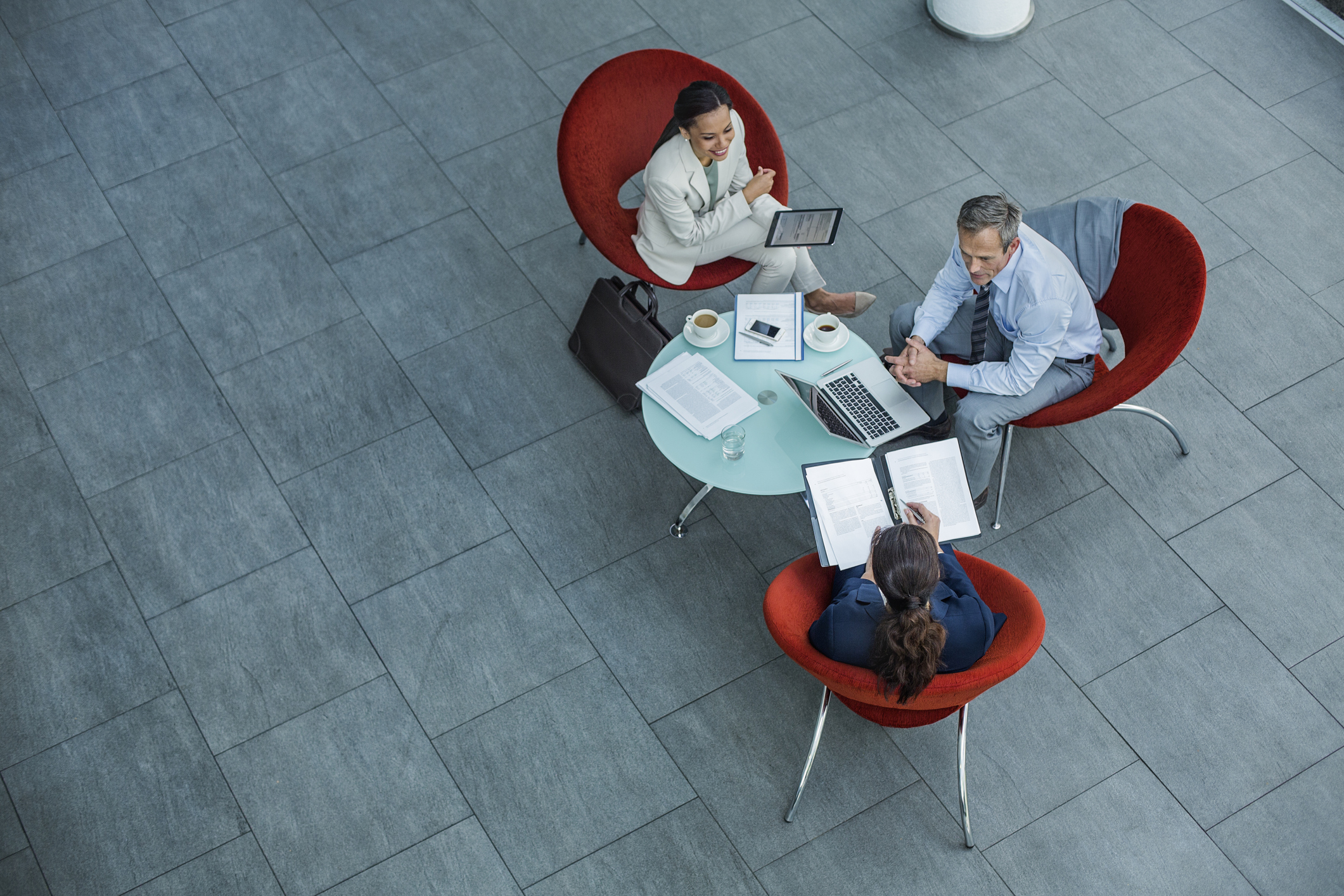 High angle view of businesspeople discussing strategy at coffee table in office